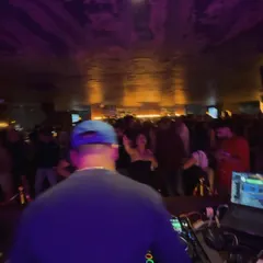 A view from behind the decks at Kaze, overlooking a packed rooftop party. The energy is always electric here.