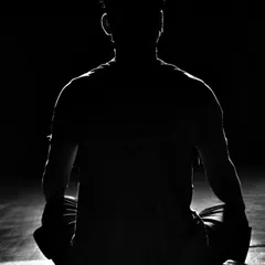 The work isn't over when the training ends. A fighter sits in meditation, calming his mind and reflecting on the session.