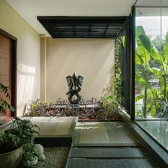 A tranquil corner of a courtyard where a sculptural Ganesha fountain is nestled among plants. This space demonstrates our use of art and water to create focal points that evoke a sense of peace and spirituality.