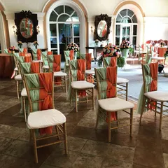 Even the chairs deserve to be dressed up. For this Catholic wedding, we decorated the Chiavari chairs with elegant orange and sea-green drapes, tying the color scheme together beautifully.