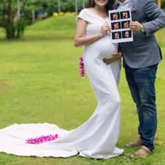 For a simple and elegant look, this white body-fit maternity gown is a perfect choice. It beautifully highlights your baby bump and comes with a small train and optional sleeves for a classic photoshoot look.