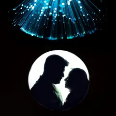 A stunning silhouette of a couple framed in a circle of light, with abstract blue light patterns above. This is a perfect example of our creative portraiture.