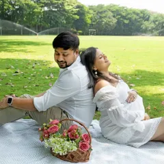 Sometimes the most magical moments happen under the open sky. This relaxed outdoor picnic shoot captures the pure, unscripted joy and laughter between two people about to become parents, surrounded by the simple beauty of nature.