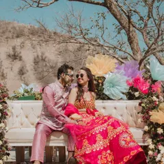 A vibrant Haldi celebration set against a stunning mountain backdrop. The couple, covered in turmeric, shares a happy moment, showcasing the fun and festive atmosphere of the day.