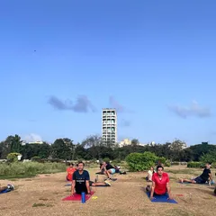 Find your focus at our Mahalaxmi Racecourse batch. Here, our members are doing cobra stretches to cool down after an intense workout, with the open sky above them.