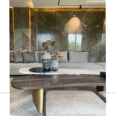 The beauty of our work is in the details. Here, a custom two-tiered coffee table, combining polished marble and rich wood, sits before a backdrop of our signature wall paneling. The interplay of textures and integrated lighting demonstrates our commitment to material excellence.