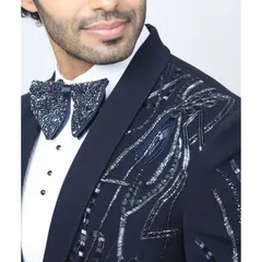 For the man who isn't afraid of some bling. This navy blue tuxedo jacket features abstract silver beadwork on the shoulders, paired with a matching embellished bow tie for a high-impact formal look.