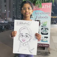 This young guest, Shravani, proudly shows off her finished caricature. I love adding names and small details to make each drawing feel personal.