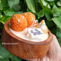 I love bringing a playful touch to tradition with my Indian dessert platter candles. This piece features realistic-looking laddoo, modak, and kaju katli candles, all made from scented soy wax and arranged in a beautiful wooden bowl.
