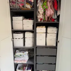After: The same wardrobe, now a system of perfect order. With labeled bins, neatly folded clothes, and clear zones, everything is easy for both parents and kids to find and, more importantly, to put away.