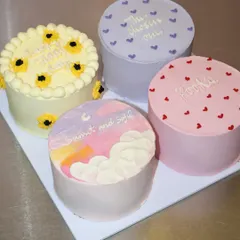 A beautiful set of four bento cakes with different themes, including hand-painted sunflowers, a dreamy pastel sky, and simple heart patterns.