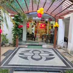 An outdoor entrance decorated for a 'Mata ki Chowki', with red and yellow balloon clusters.