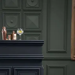 A close-up of classic wainscoting in a deep, moody green. This type of wall treatment adds architectural depth and a touch of traditional elegance, perfect for creating a cozy bar area or study.