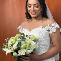 A beautiful, smiling portrait of the bride, her soft makeup and romantic curls perfectly complementing her lace gown and delicate veil.