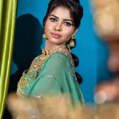 A slightly different angle of the semi-traditional look, this shot offers a clear view of the makeup and jewelry. The soft foreground blur adds a touch of artistry and depth.