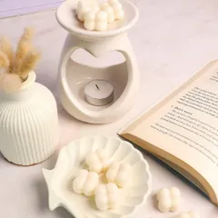 A perfect reading nook setup featuring our heart diffuser, shell-shaped trinket dish, and mini bubble wax melts. Unwind and indulge in enchanting scents.
