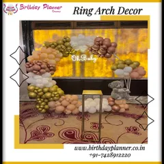 A lovely "Oh Baby" themed decoration featuring a half-ring balloon arch in gold, rose gold, and white. A small teddy bear prop adds a touch of sweetness to this baby shower photo corner.