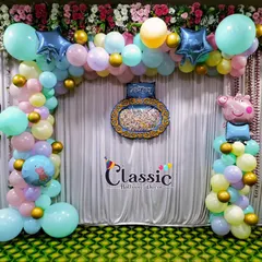 A Peppa Pig themed decoration for a naming ceremony, using a pastel balloon arch and a traditional centerpiece.