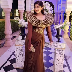 A stunning brown gown with a dramatic, embroidered collar. This is a perfect example of a statement piece for a wedding function that is both timeless and trendy.