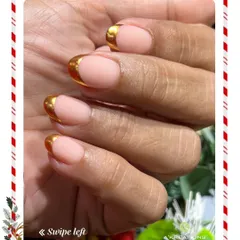 A glamorous and modern chrome French manicure. This design features a natural nude base with bold, reflective gold tips for a striking holiday look.