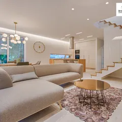 An example of a spacious, open-plan living area that combines the living room, dining space, and kitchen. The design uses a neutral color palette, modern furniture, and strategic lighting to create a sense of flow and sophistication.