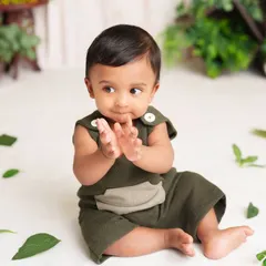 A handsome little man clapping his hands during his sitter session. His joyful expression and the simple, natural setup keep all the focus on him.