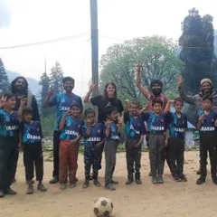 The joy of teamwork. This group photo with kids and local supporters captures the successful conclusion of our football camp. The smiles and victory signs say everything about the positive spirit we built.