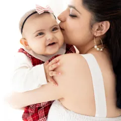 A mother's gentle kiss on her baby's cheek. These simple, light-filled portraits are perfect for capturing the pure love and connection with your little one.