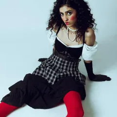 A creative and conceptual portrait with a vintage doll-like aesthetic. The styling, with its plaid skirt, puffed sleeves, and bright red tights, is highly theatrical. My job was to create a mood and composition that felt both playful and slightly unsettling.