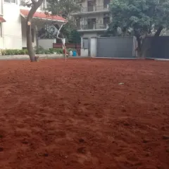 The first and most important step of any great garden: soil preparation. Here, a large area is being covered with enriched red soil before any planting or lawn installation begins.