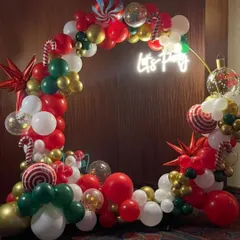 This 'Let's Party' ring arch is decorated for Christmas with red, green, white, and gold balloons, along with fun accents like candy cane and starburst foil balloons.