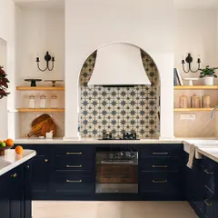 The kitchen is the heart of the home, and I designed this one to be a showstopper. The custom arched range hood, paired with a bold cement tile backsplash, creates a stunning focal point, while the deep blue custom cabinets provide ample, beautiful storage for a space that is as functional as it is breathtaking.