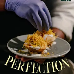 The final touch. A chef carefully plates a dish, ensuring every detail is perfect. This is the passion I value in my team.