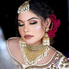 A stunning gold-plated choker with cascading pearls, paired with matching jhumkas and maang tikka.