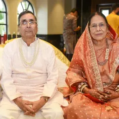 A classic portrait of the couple of honor at their golden anniversary party, dressed in elegant traditional attire.