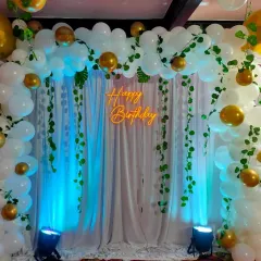 A full, straight-on shot of the jungle-themed birthday setup. The combination of white balloons and gold chrome accents adds a touch of elegance to the playful theme.