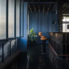 Light reflects off the polished black herringbone floor, adding depth and glamour to the bar's interior. The interplay of light and shadow is a key component of my design, used here to create a space that feels both intimate and dramatic.
