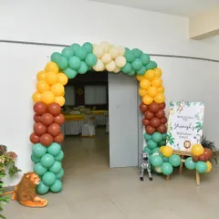A simple yet effective jungle-themed entrance arch with a personalized welcome board.