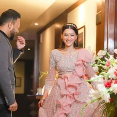 The groom's joyful reaction upon seeing his stunning bride-to-be at their engagement. Her bright smile shows her happiness in this beautiful, candid moment.