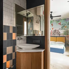 A view from the kid's bathroom into the jungle-themed bedroom. The design uses a corner vanity to maximize space, while the checkered tiles add a touch of playful geometry.