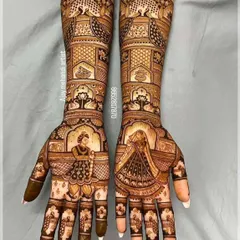 This design is a masterpiece of symmetry and detail. It features bride figurines in a doli, surrounded by peacocks, paisleys, and delicate floral work.