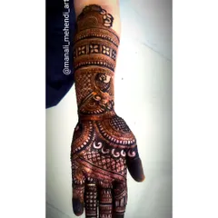 An intricate mehandi design covering the hand and forearm. This piece combines floral, peacock, and geometric patterns, typical of traditional bridal mehandi.