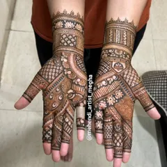 This design is packed with detail, featuring peacock feather patterns, checkerboards, and floral bands. It's a great example of a full, dense mehendi look.