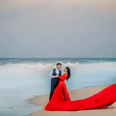 The drama of the sea meets the elegance of this flowing red gown. For this beach pre-wedding shoot, I wanted to create a powerful, vibrant image that felt both romantic and epic. The contrast of the red against the moody sky and waves makes this a standout shot.