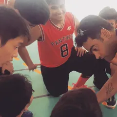 A team huddle during a timeout, where I am giving strategic advice to our young players. These moments of guidance and team bonding are crucial for on-court success and building player confidence.