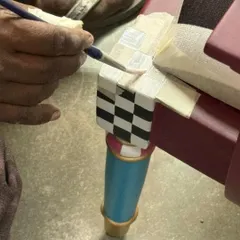 The soul of my work is in the handcrafted details. Here, an artisan meticulously hand-paints the checkerboard pattern on the leg of our chess-inspired bench, using traditional techniques to ensure sharp lines and rich character.