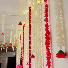 A simple yet stunning ceiling treatment using strings of red and white flowers interspersed with fairy lights. This creates a magical, starry-night effect that is perfect for any celebration.