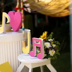 A close-up of the music-themed decor, with bright pink musical note cutouts and a fresh floral arrangement, showcasing the playful and colorful vibe of the event.