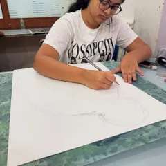 A high school student works on a detailed pencil drawing for her portfolio. We focus on building strong foundational skills in drawing and composition, which are essential for any art and design discipline.