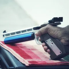 A shooter's hand gripping a 10m air pistol. The custom anatomical grip ensures a consistent and firm hold, which is vital for stability and shot control.
